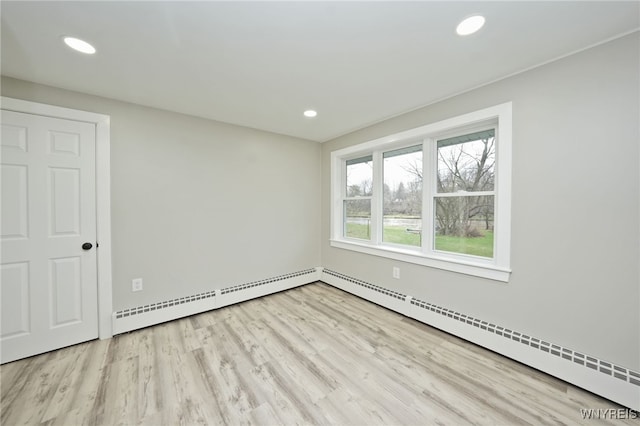 unfurnished room with recessed lighting, wood finished floors, a baseboard heating unit, baseboards, and baseboard heating