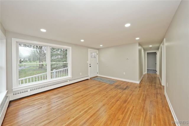 unfurnished room featuring recessed lighting, light wood-type flooring, baseboards, and baseboard heating