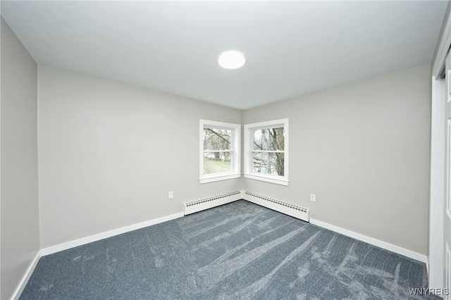empty room featuring dark colored carpet, baseboards, and baseboard heating