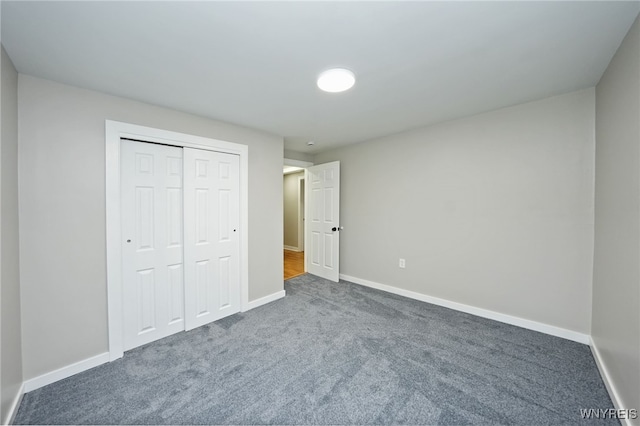 unfurnished bedroom with baseboards, a closet, and carpet