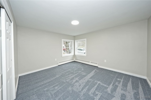 empty room with dark carpet, a baseboard radiator, and baseboards