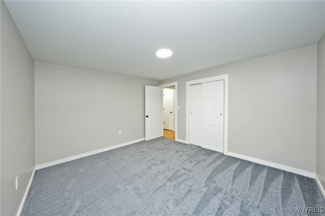 unfurnished bedroom featuring carpet floors, a closet, and baseboards