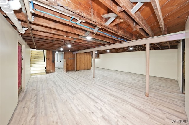 finished basement featuring light wood finished floors and stairs