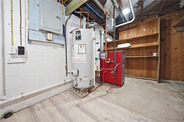 utilities with water heater, electric panel, and a heating unit