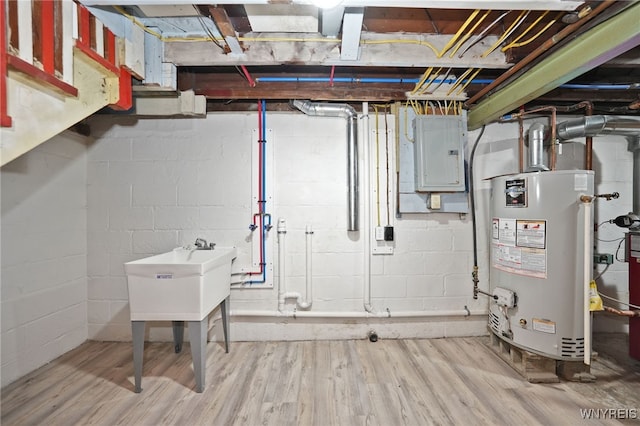 unfinished below grade area featuring water heater, wood finished floors, and electric panel