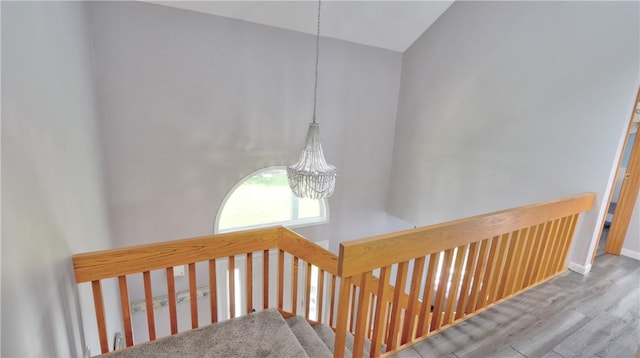 interior space featuring baseboards, vaulted ceiling, wood finished floors, and a chandelier