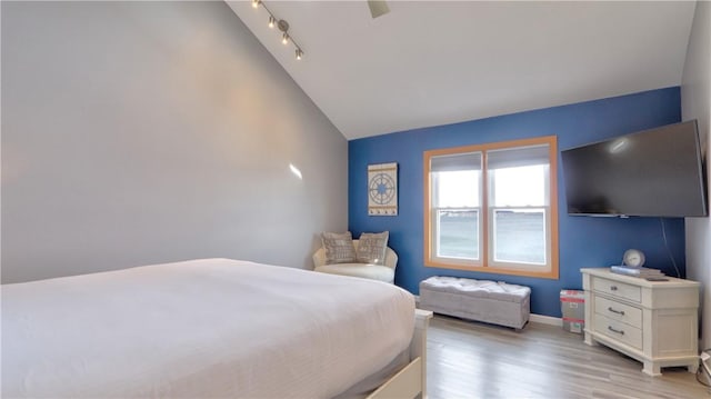 bedroom featuring baseboards, lofted ceiling, and light wood-style flooring