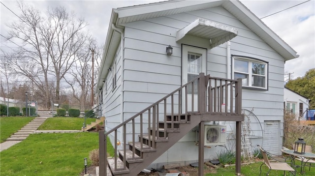 property entrance with a yard and ac unit