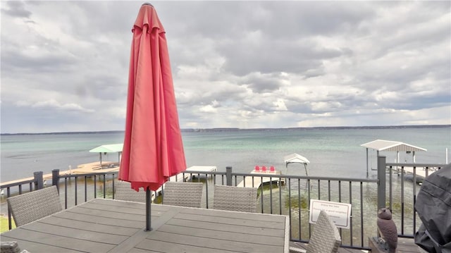 wooden terrace featuring outdoor dining area and a water view