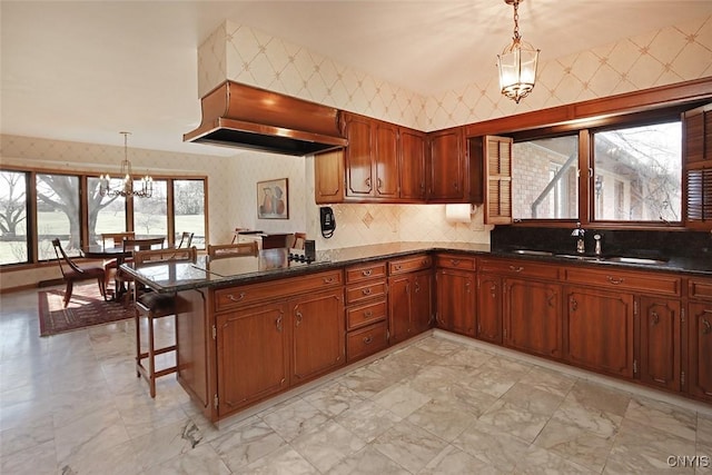 kitchen with wallpapered walls, a peninsula, black electric cooktop, and custom range hood
