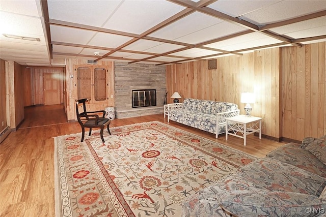 living room with wood walls, a large fireplace, and wood finished floors