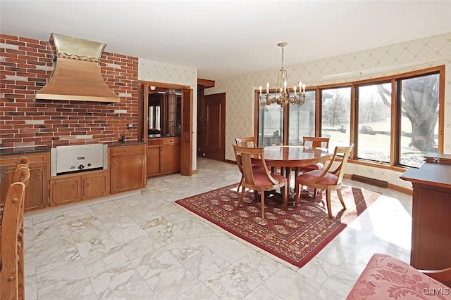 dining space with marble finish floor, a notable chandelier, and wallpapered walls
