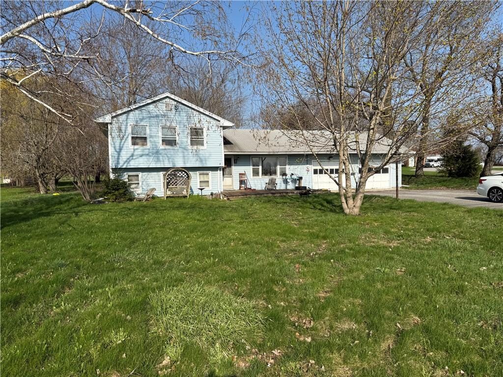 split level home with an attached garage, driveway, and a front yard
