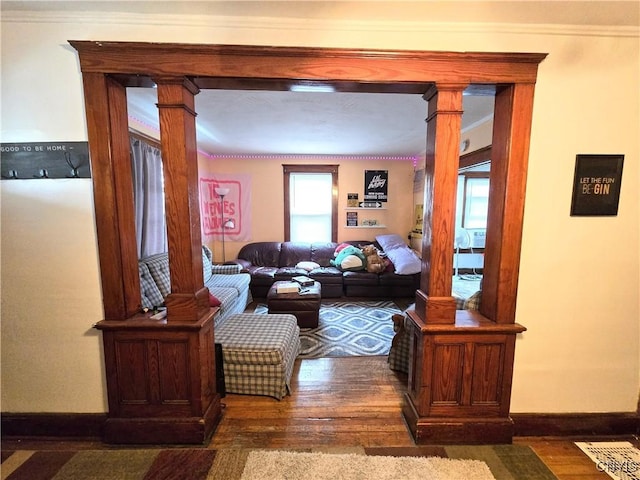 living room with hardwood / wood-style flooring, baseboards, ornate columns, and a healthy amount of sunlight