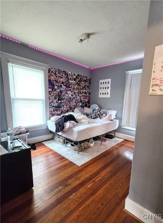bedroom with wood finished floors and baseboards