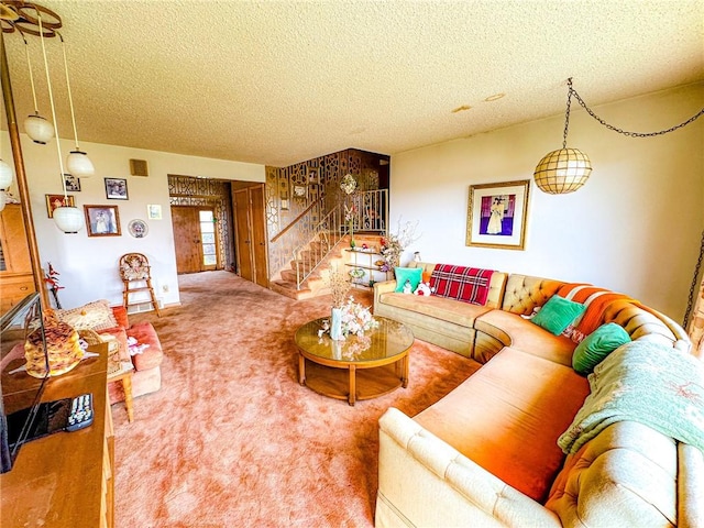 carpeted living area with a textured ceiling and stairway