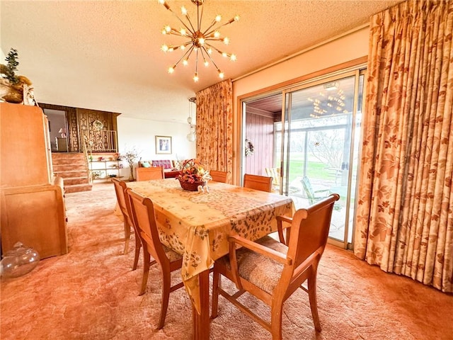 dining area with light carpet, a textured ceiling, and an inviting chandelier