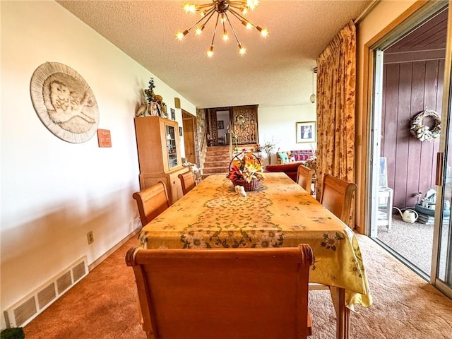 carpeted dining space with a chandelier, visible vents, and a textured ceiling