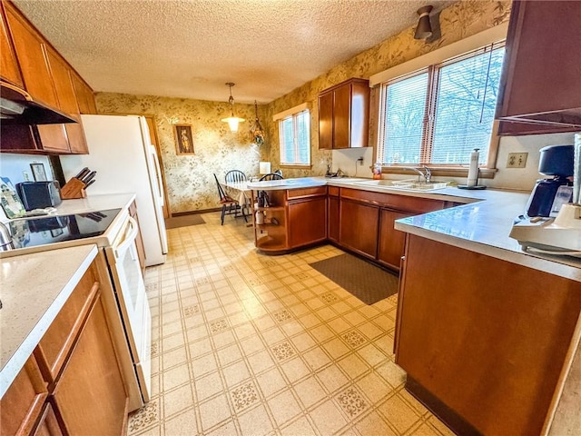 kitchen featuring wallpapered walls, electric stove, a sink, brown cabinetry, and a textured ceiling