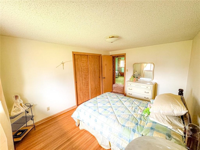 bedroom featuring a textured ceiling, wood finished floors, and a closet
