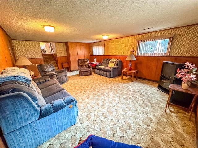 living room with wallpapered walls, wooden walls, and a textured ceiling