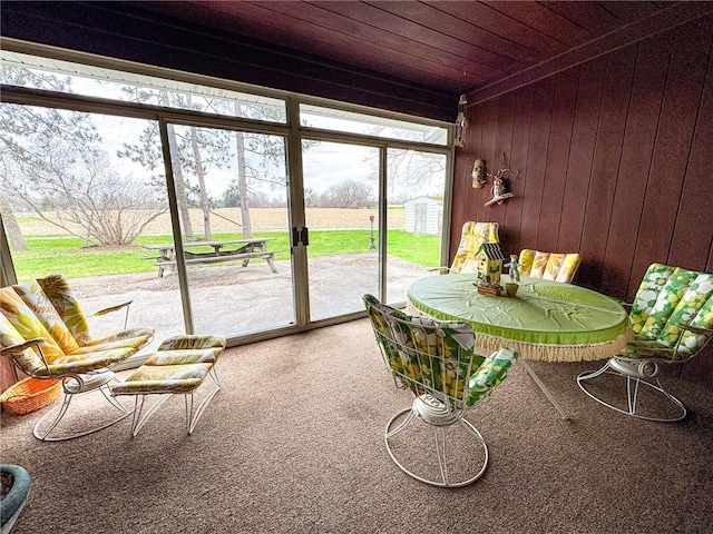 sunroom / solarium with wooden ceiling, wood walls, and carpet floors