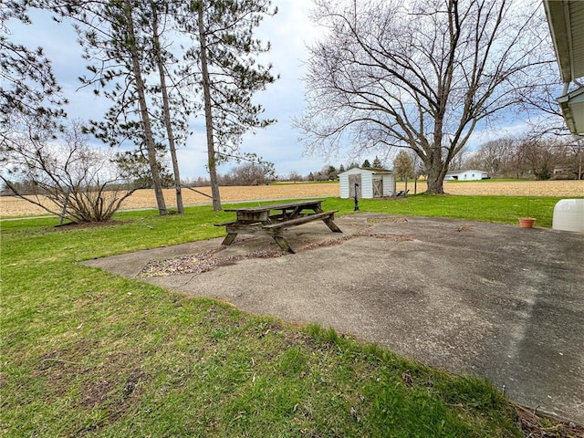 view of home's community with a yard, a storage unit, and an outbuilding