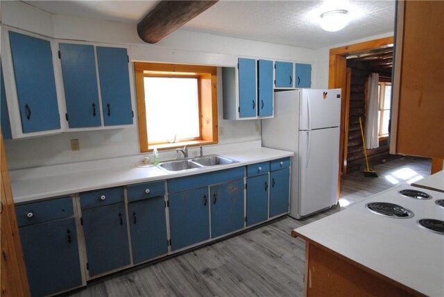 9221 Health St, North Dansville, NY 14437 - kitchen featuring a sink, freestanding refrigerator, blue cabinetry, and wood finished floors