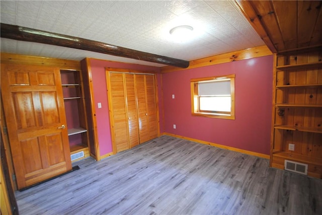 9221 Health St, North Dansville, NY 14437 - unfurnished bedroom featuring visible vents, baseboards, wood finished floors, and beam ceiling