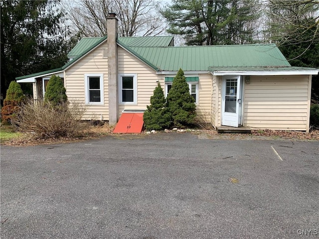 view of front of house with a chimney and metal roof
