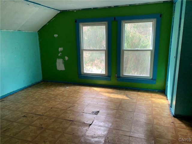 bonus room with vaulted ceiling and baseboards