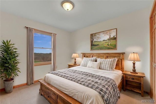 bedroom with baseboards and light carpet