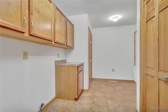 laundry room with baseboards and light tile patterned floors