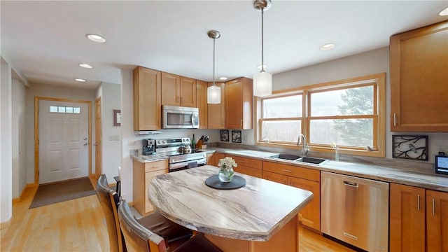 kitchen featuring a sink, light wood-style floors, appliances with stainless steel finishes, a kitchen island, and recessed lighting
