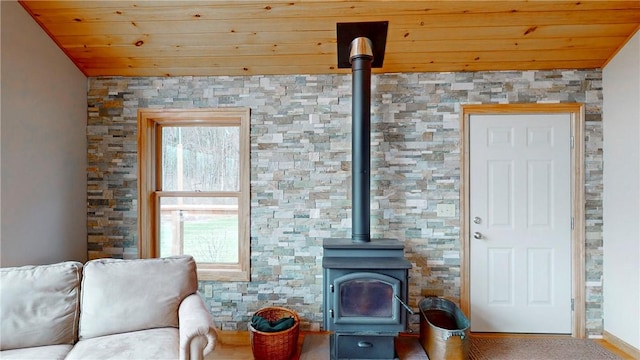 living area featuring wood ceiling and a wood stove