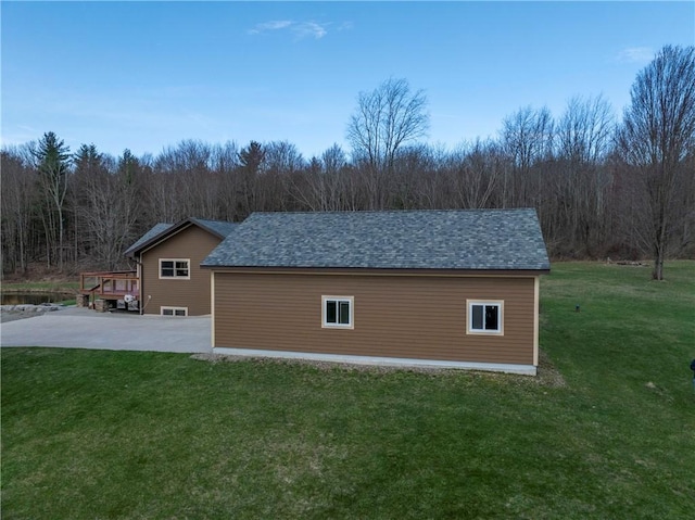 view of home's exterior featuring a patio area, a forest view, and a yard