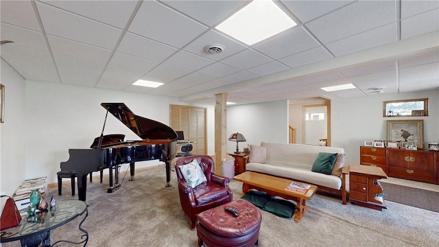 carpeted living area featuring visible vents and a drop ceiling