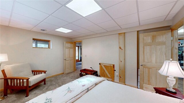 carpeted bedroom with baseboards and a drop ceiling