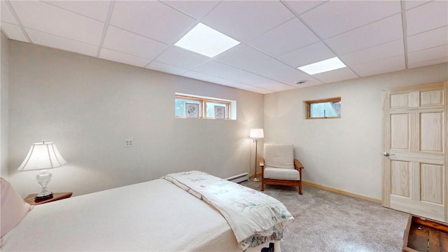 carpeted bedroom with baseboards, a paneled ceiling, and baseboard heating