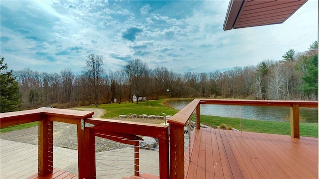 wooden terrace featuring a yard, a view of trees, and a water view