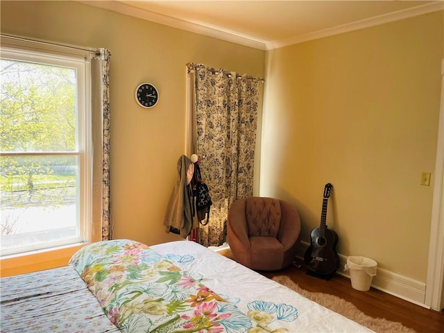 bedroom with baseboards, wood finished floors, and ornamental molding