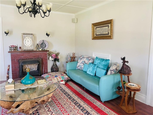 living room with wood finished floors, ornamental molding, a fireplace, baseboards, and a notable chandelier