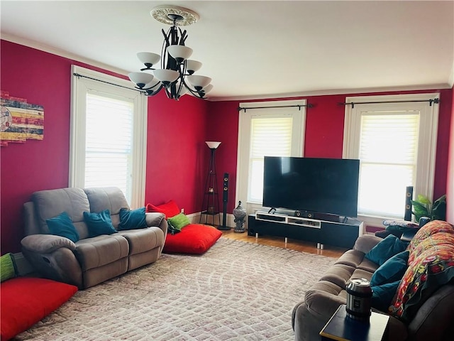living room featuring wood finished floors, crown molding, and a notable chandelier
