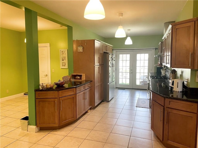 kitchen with brown cabinets, french doors, stainless steel appliances, and light tile patterned floors