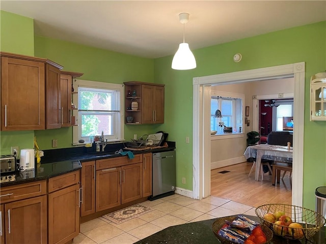 kitchen with dishwasher, brown cabinetry, light tile patterned flooring, and pendant lighting