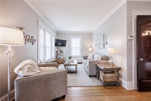 living area with baseboards, wood finished floors, and crown molding