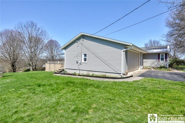 view of home's exterior featuring driveway, a yard, and a garage
