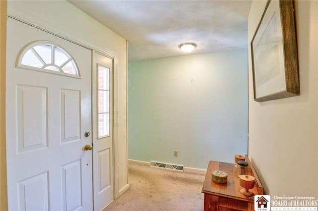 carpeted foyer featuring baseboards and visible vents