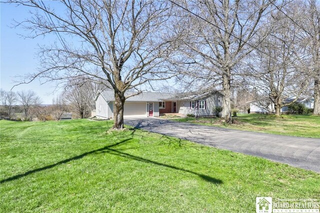 view of front facade with a garage, driveway, and a front lawn