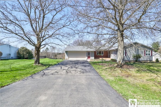 ranch-style house featuring an attached garage, a front lawn, and driveway